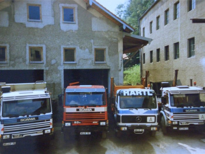 Vier Lkw des Fuhrparks um 1990 vor dem Betriebsgebäude