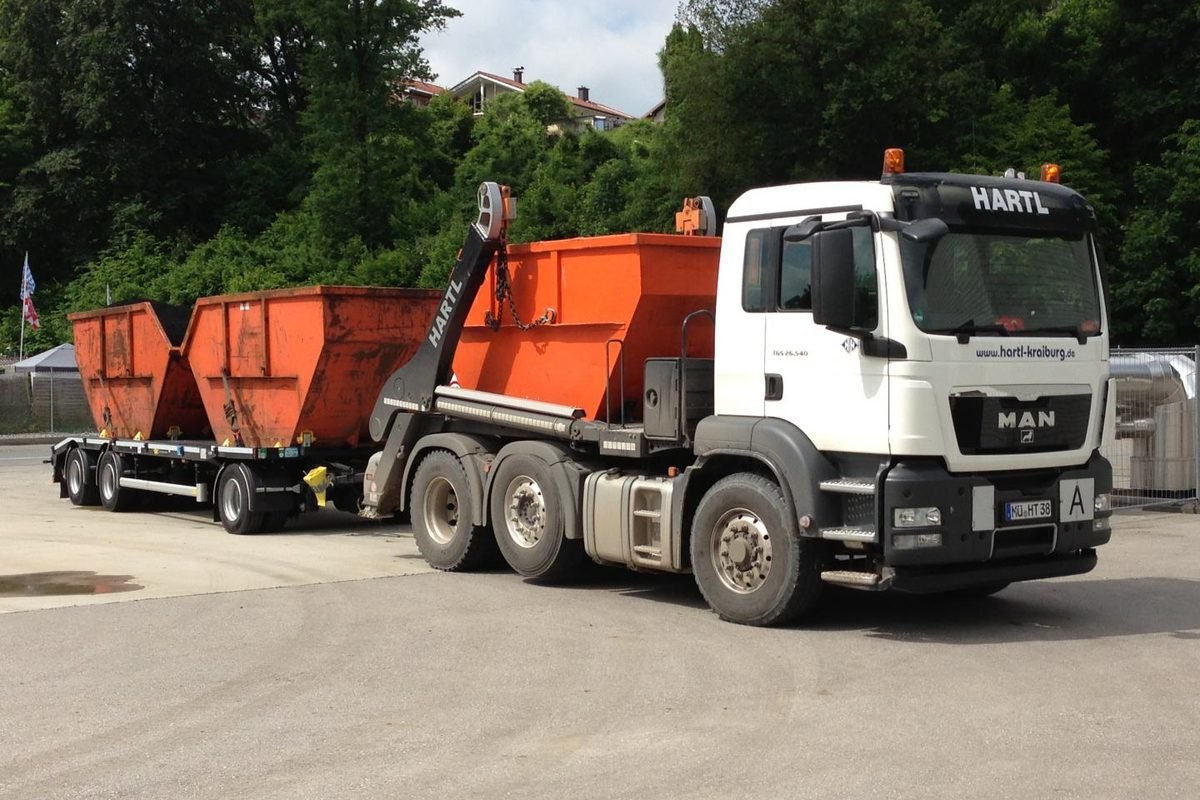 Lkw von Hartl mit Anhänger und zwei orangen Absetzmulden
